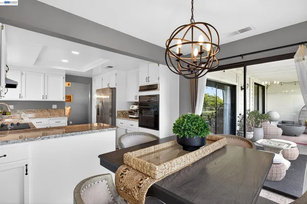 a kitchen with stainless steel appliances granite countertop a stove and a chandelier