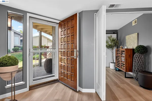 a view of a hallway with wooden floor and windows
