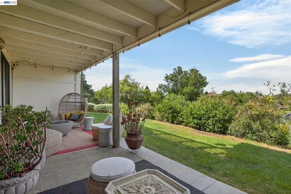 a view of a porch with furniture and a yard