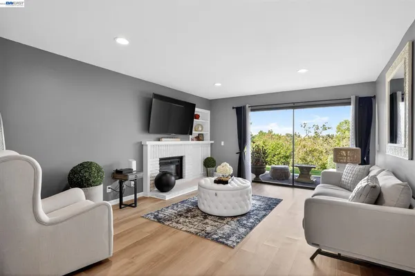 a living room with furniture a fireplace and a flat screen tv