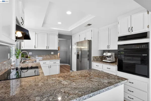 a kitchen with stainless steel appliances granite countertop a refrigerator stove microwave and sink