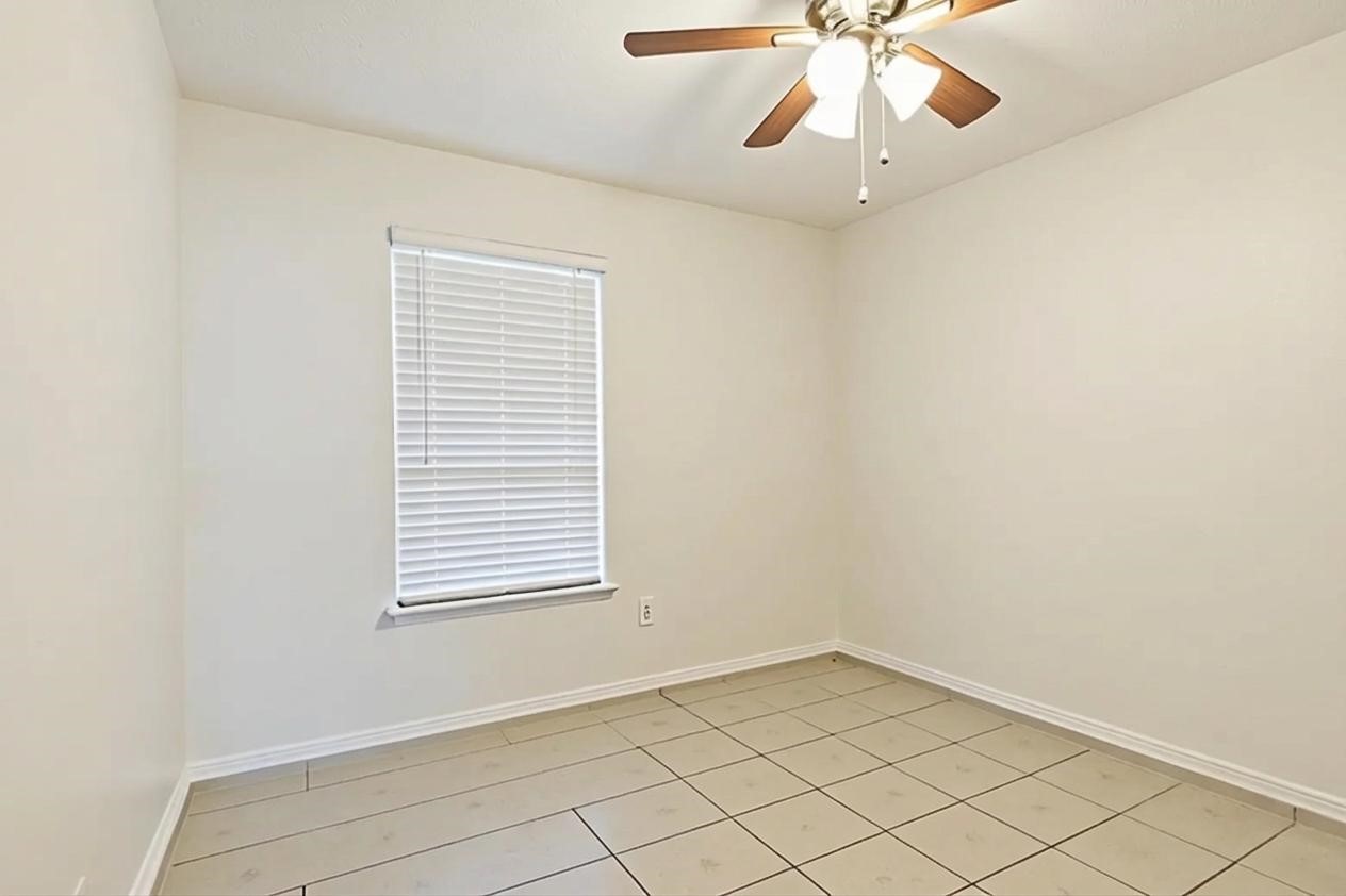 15258 Ferness Lane Channelview, TX 77530 - Photo 10 of 16 an empty room with a window and a fan