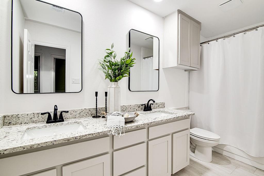 715 Pheasant Run Burleson, TX 76028 - Photo 18 of 28 a bathroom with a toilet sink and mirror