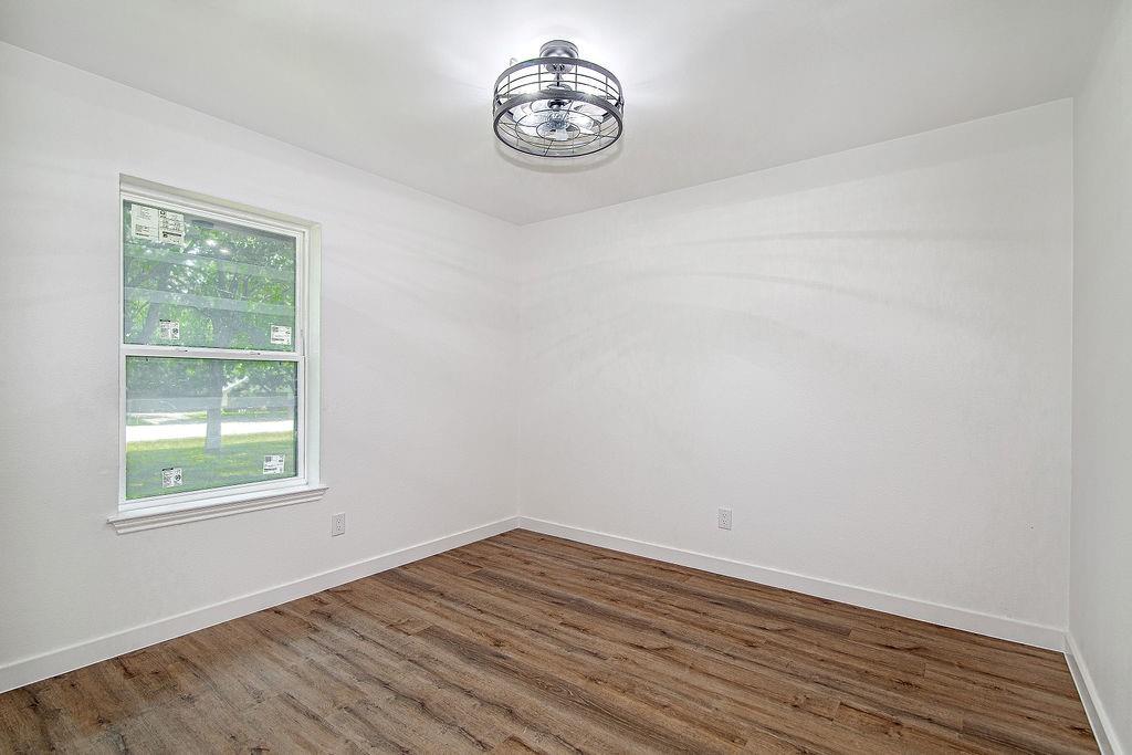 715 Pheasant Run Burleson, TX 76028 - Photo 19 of 28 an empty room with wooden floor and a window