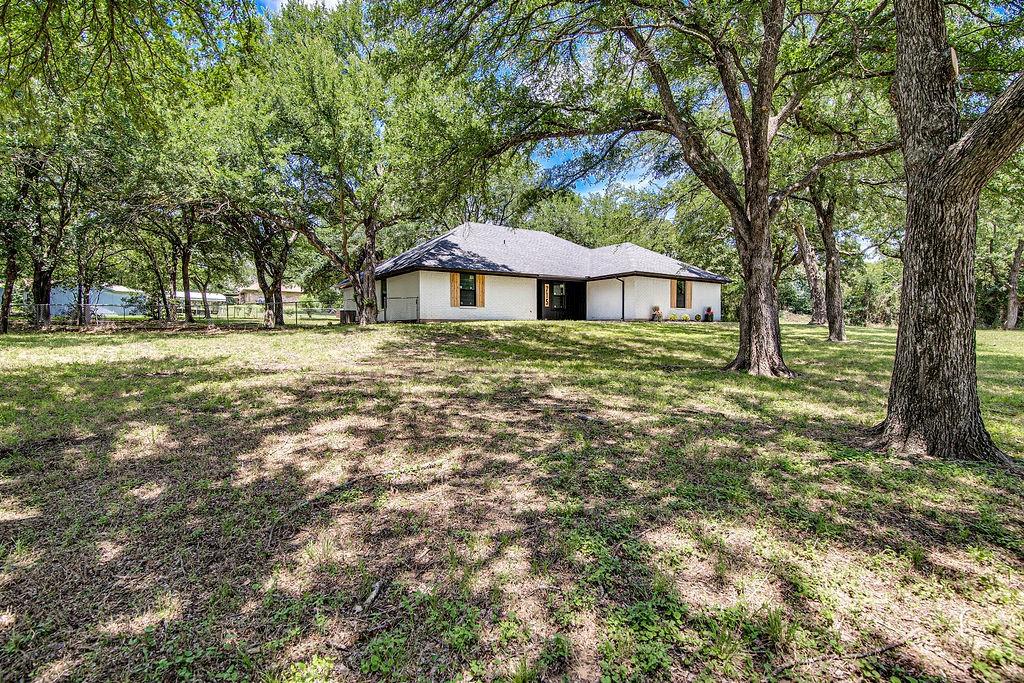 715 Pheasant Run Burleson, TX 76028 - Photo 26 of 28 a white house in middle of the forest