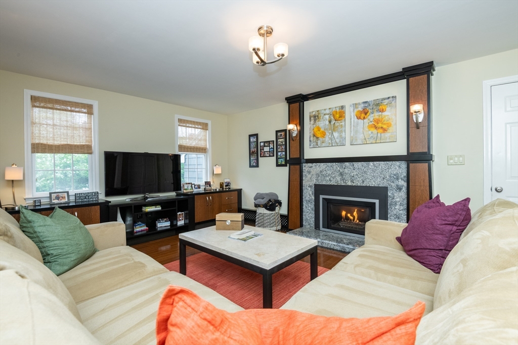 25 Ellen Road Stoneham, MA 02180 - Photo 8 of 41 a living room with furniture a flat screen tv and a fireplace