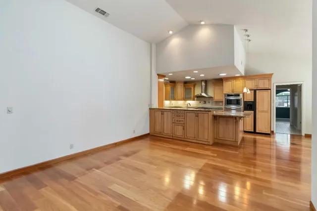 a kitchen with stainless steel appliances granite countertop a refrigerator and a stove top oven