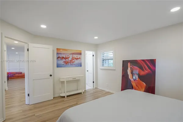 a bedroom with a large bed and a painting on the wall