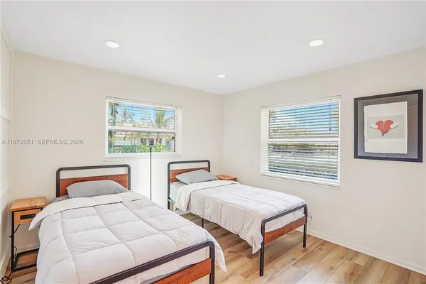 a bedroom with two beds and a window