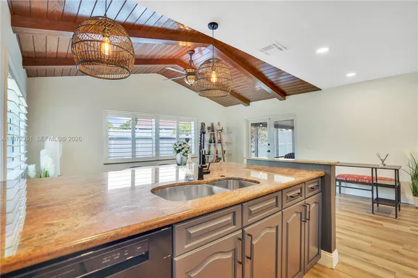 a kitchen with stainless steel appliances granite countertop a sink and a wooden cabinets