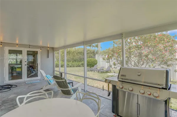 a view of a living room with furniture and large windows