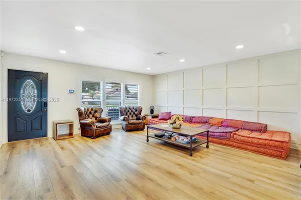 a living room with furniture a window and a wooden floor