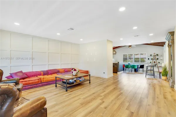 a living room with furniture and a wooden floor