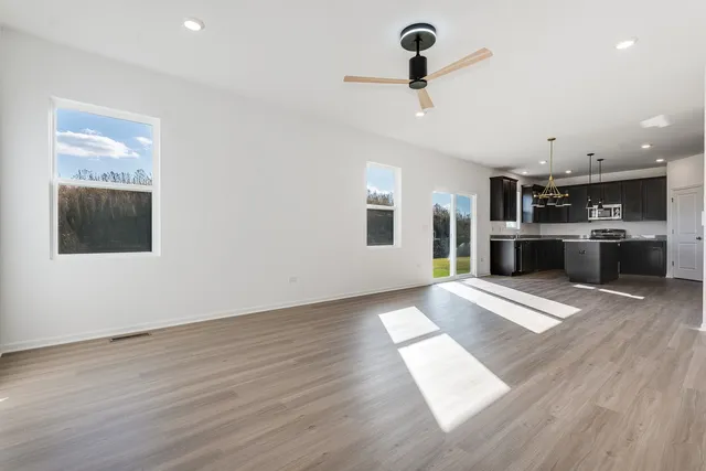 a view of a kitchen with a sink stove cabinets and empty room
