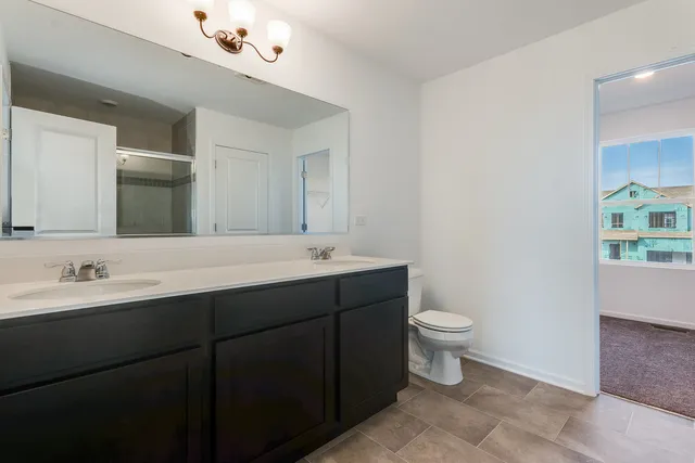 a bathroom with a double vanity sink mirror and toilet