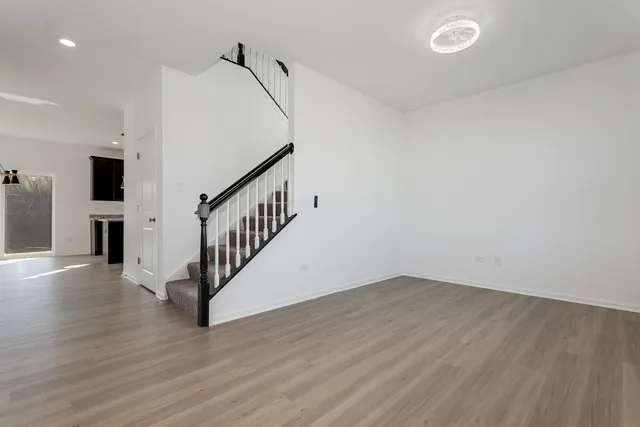 a view of staircase with wooden floor and white walls