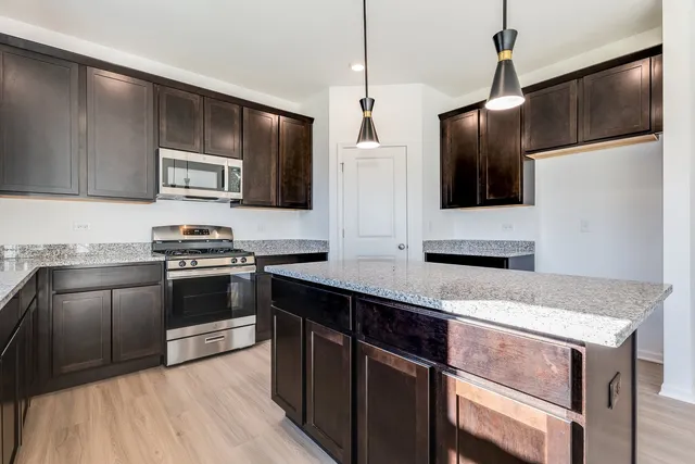 a kitchen with kitchen island granite countertop stainless steel appliances and sink