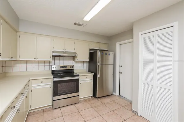 a kitchen with white cabinets and stainless steel appliances