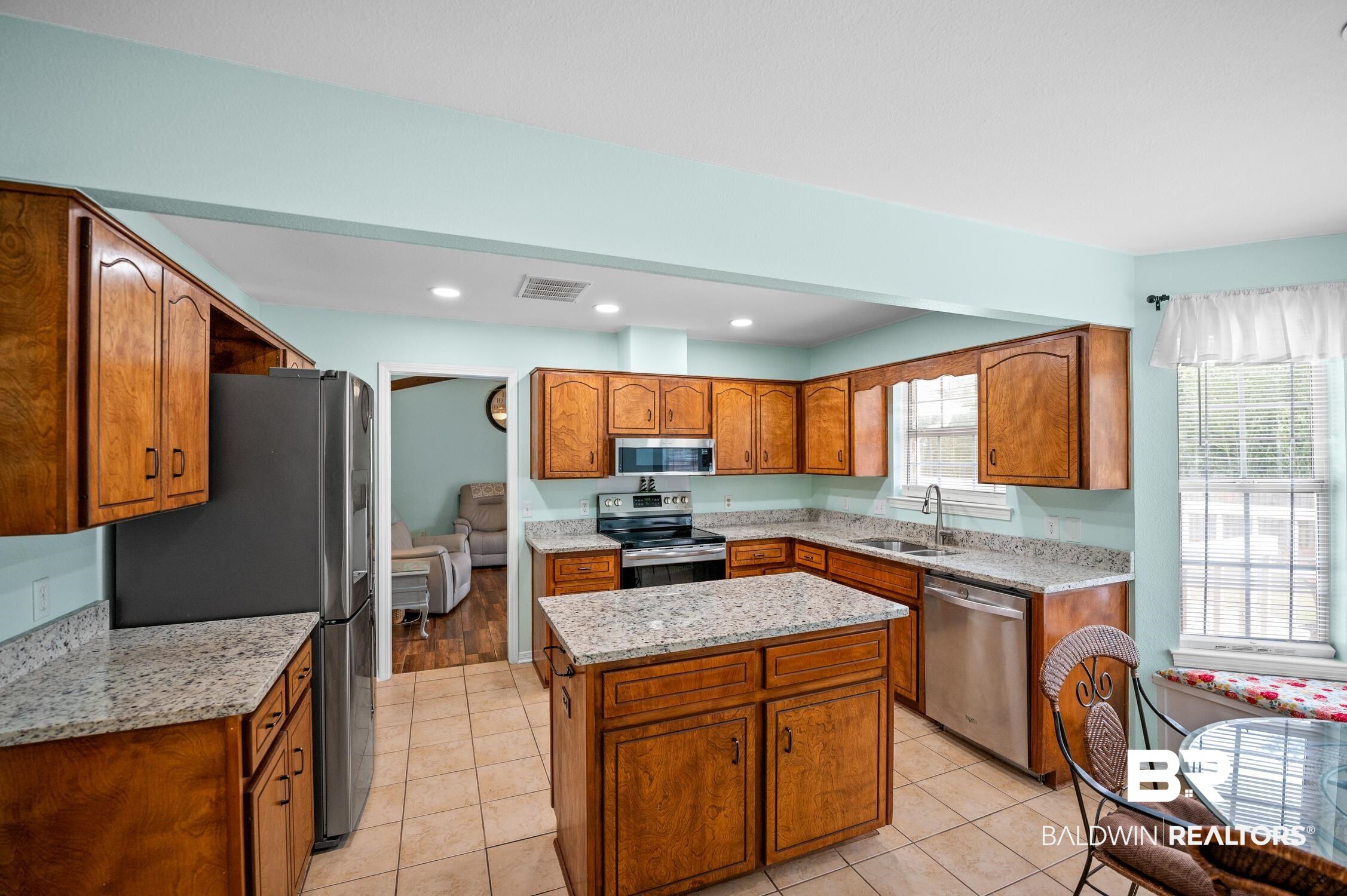 2553 Santa Rosa Drive Lillian, AL 36549 - Photo 19 of 51 Kitchen featuring visible vents, a kitchen island, appliances with stainless steel finishes, brown cabinets, and a sink