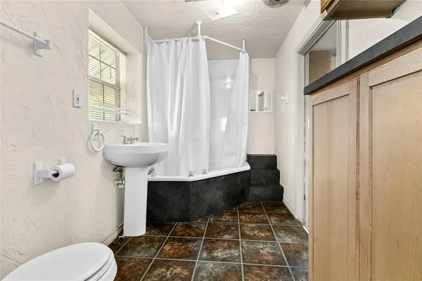 a bathroom with a sink toilet and shower