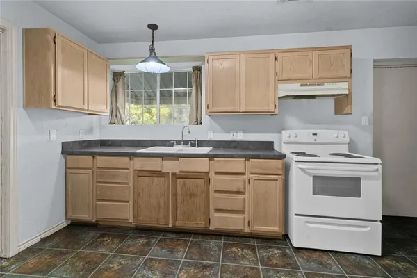 a kitchen with stainless steel appliances granite countertop a sink stove and cabinets