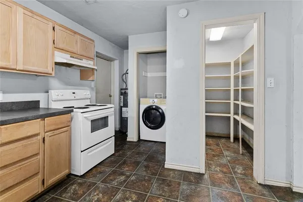 a kitchen with a sink a stove and cabinets