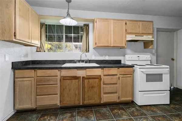 a kitchen with stainless steel appliances a sink stove and cabinets