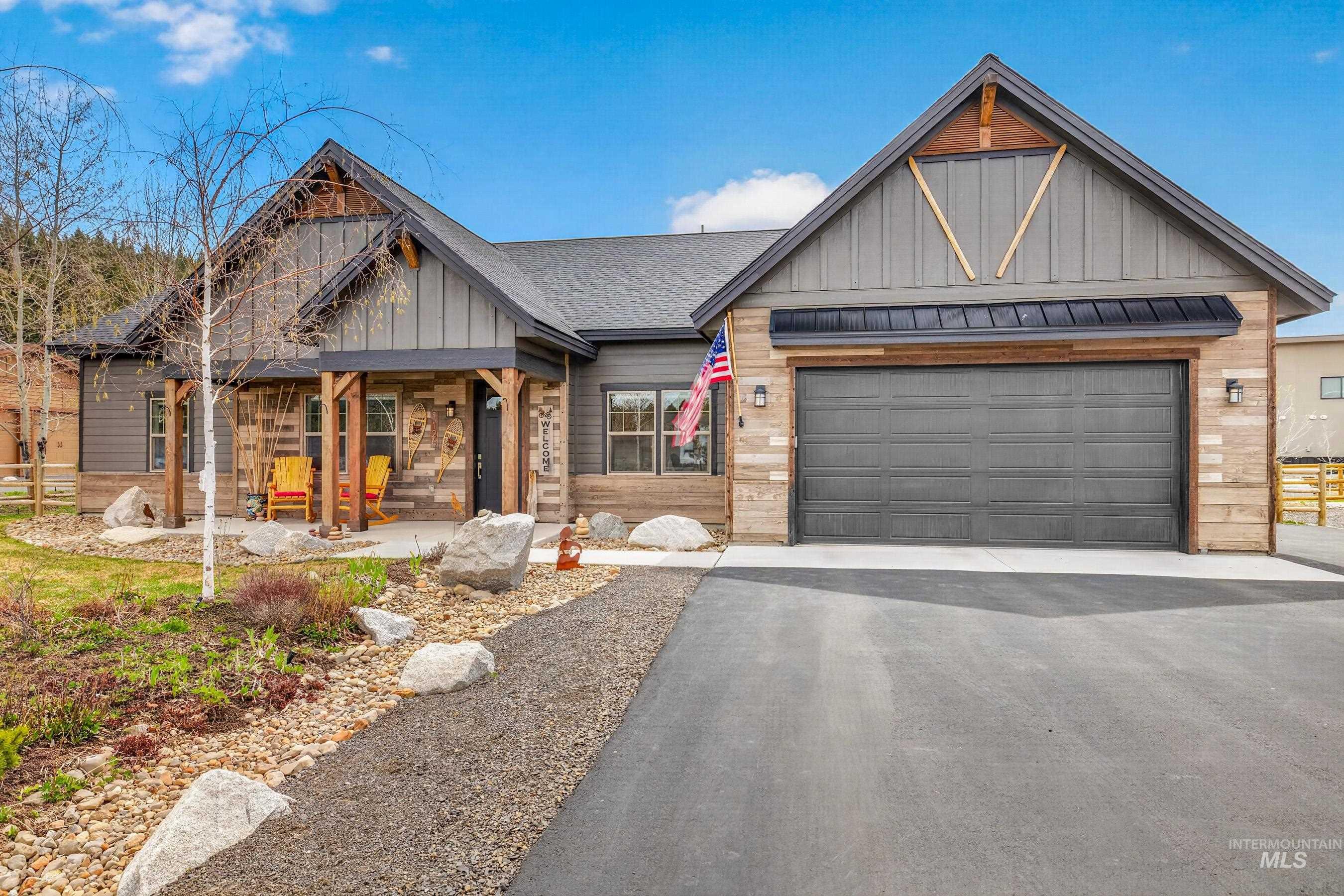 Craftsman-style exterior featuring a covered front porch with timber posts, stone accents, and vertical siding