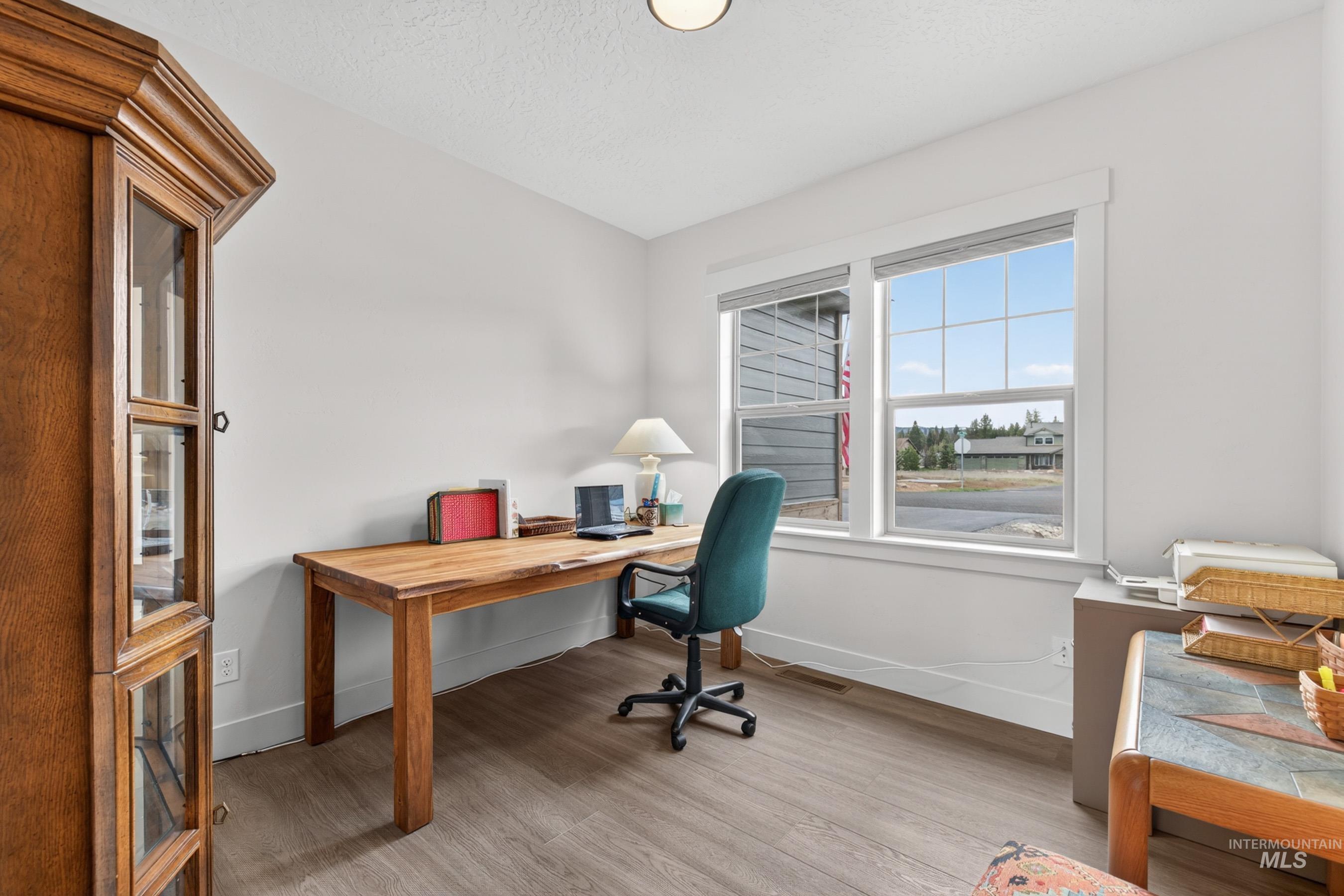 1126 Mo's Way McCall, ID 83638 - Photo 21 of 50 Bright room featuring neutral wall tones, wood-finish flooring, and a large window with grid panes