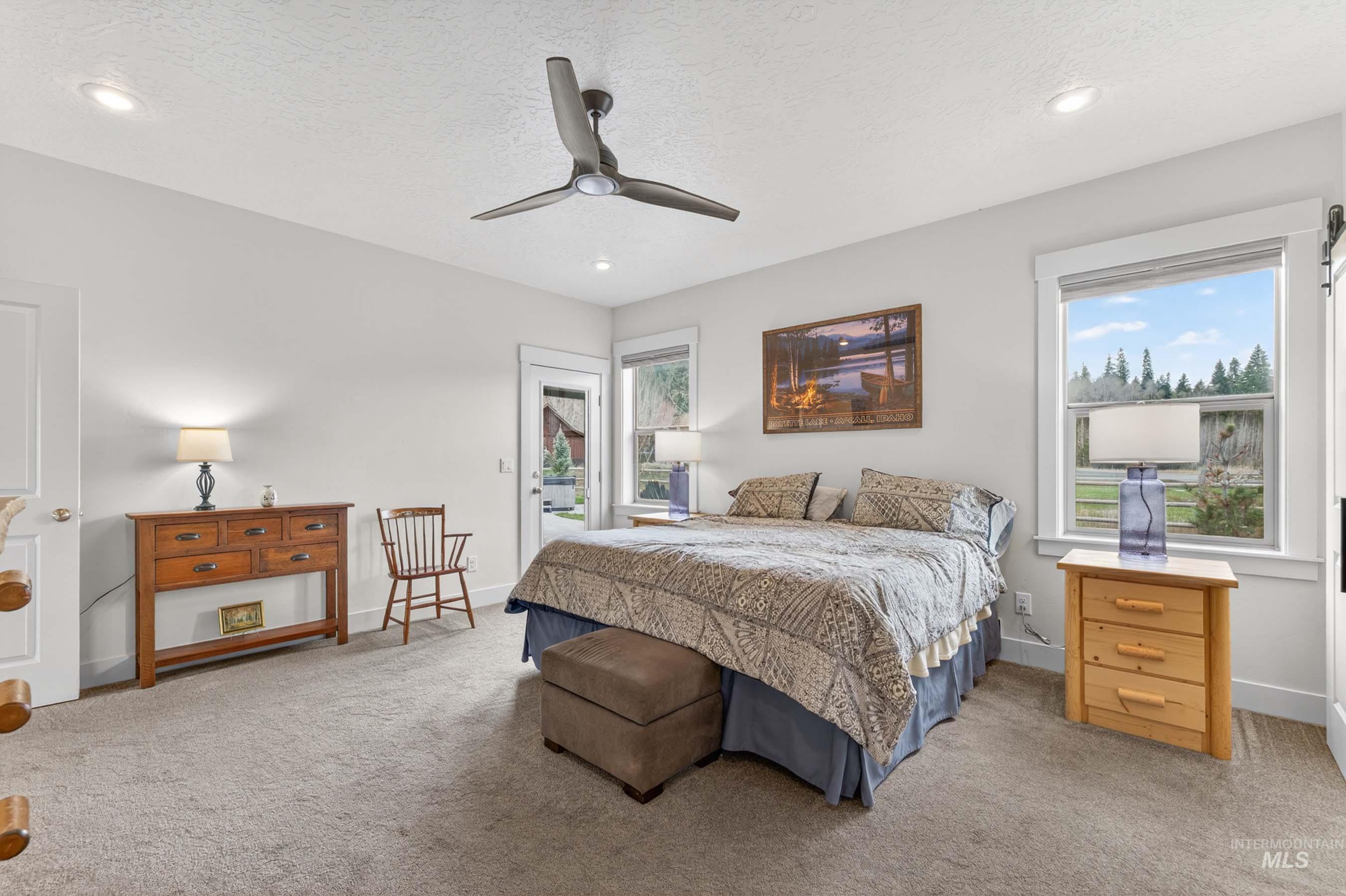 1126 Mo's Way McCall, ID 83638 - Photo 23 of 50 Spacious bedroom with carpeted flooring, a ceiling fan, recessed lighting, and a large window providing natural light