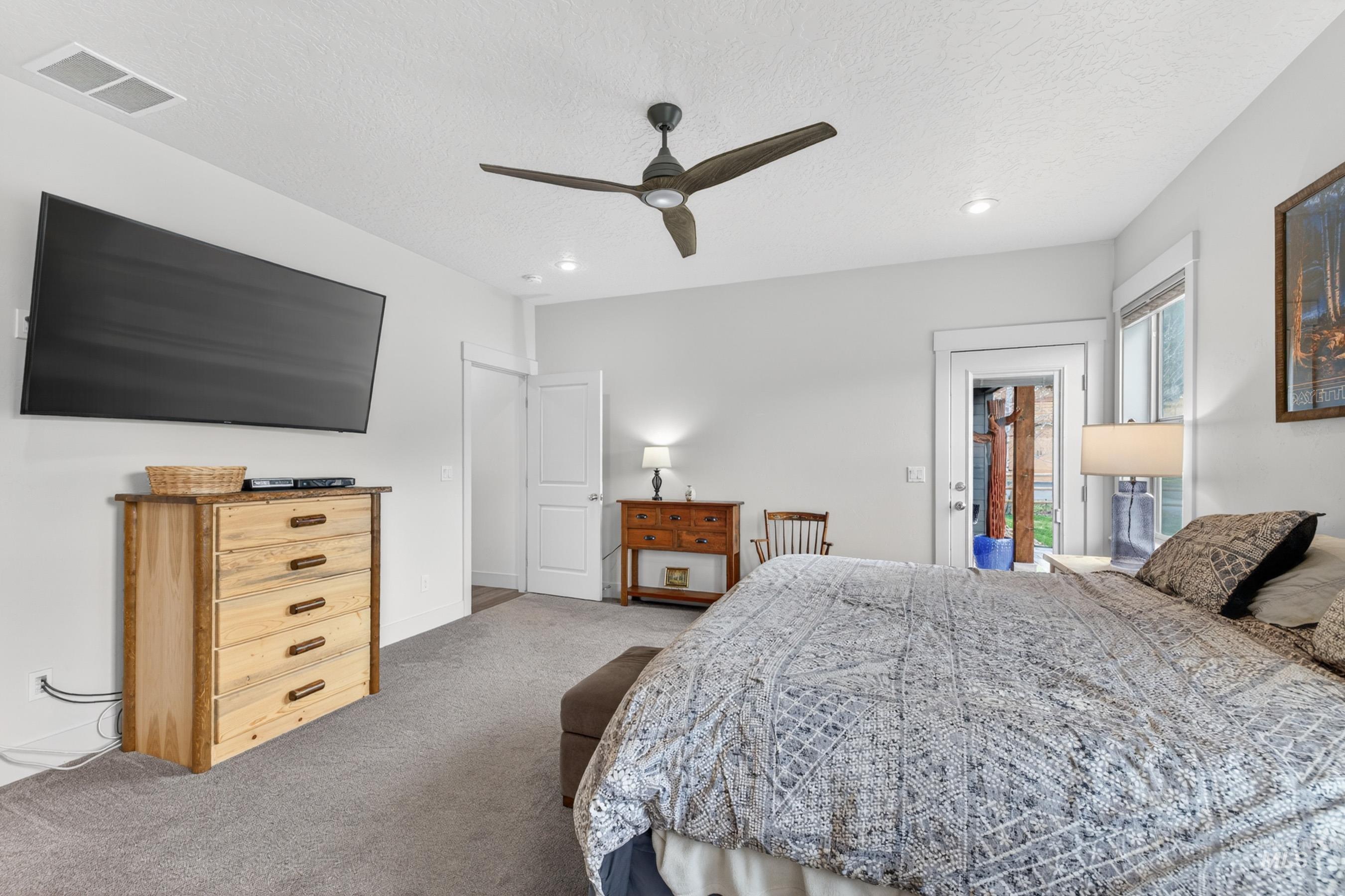 1126 Mo's Way McCall, ID 83638 - Photo 24 of 50 Bedroom featuring light gray walls, gray carpet, a ceiling fan with integrated lighting, recessed lighting, and a glass-paneled door providing exterior access