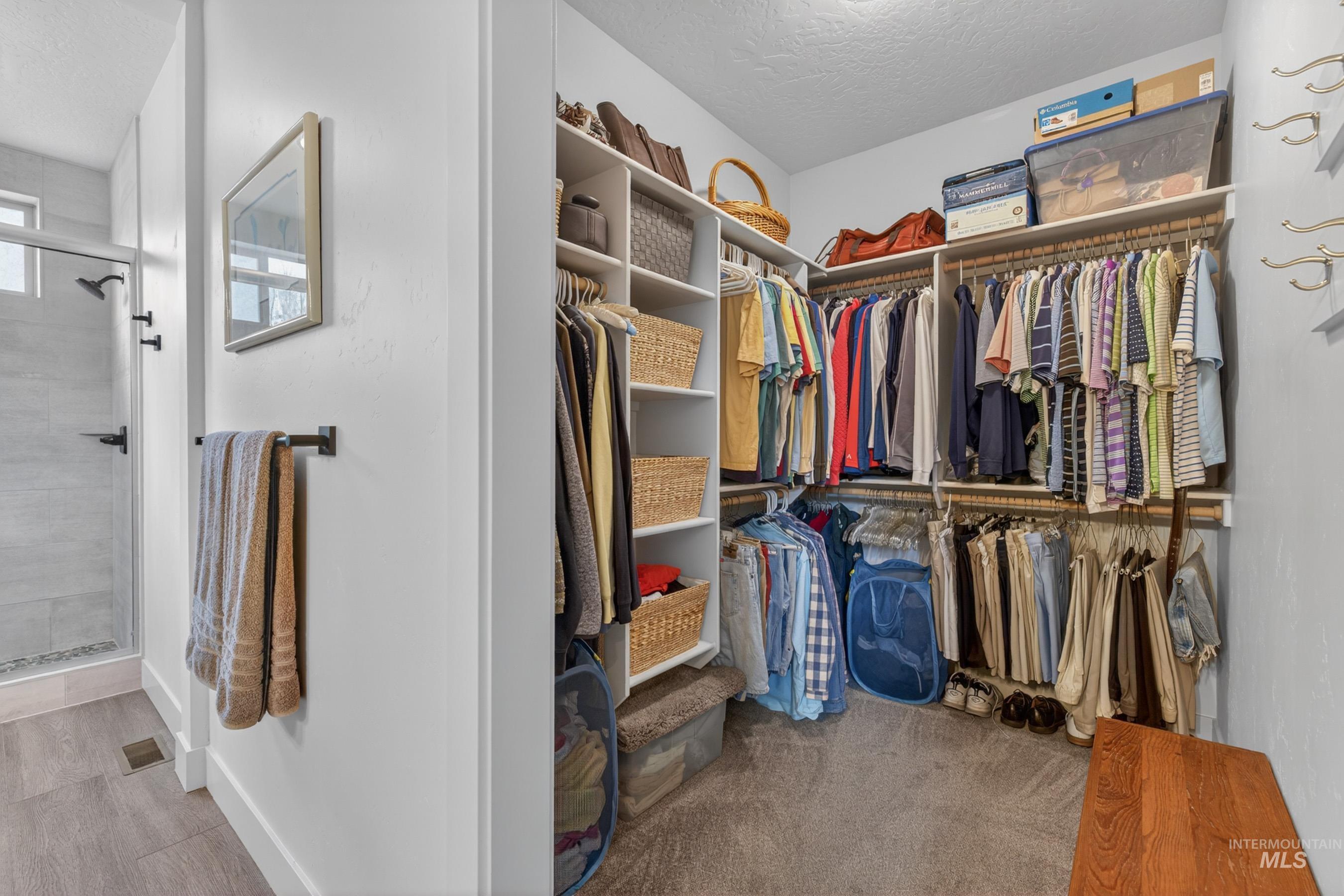 1126 Mo's Way McCall, ID 83638 - Photo 27 of 50 Walk-in closet featuring extensive built-in shelving, multiple hanging rods, and carpet flooring