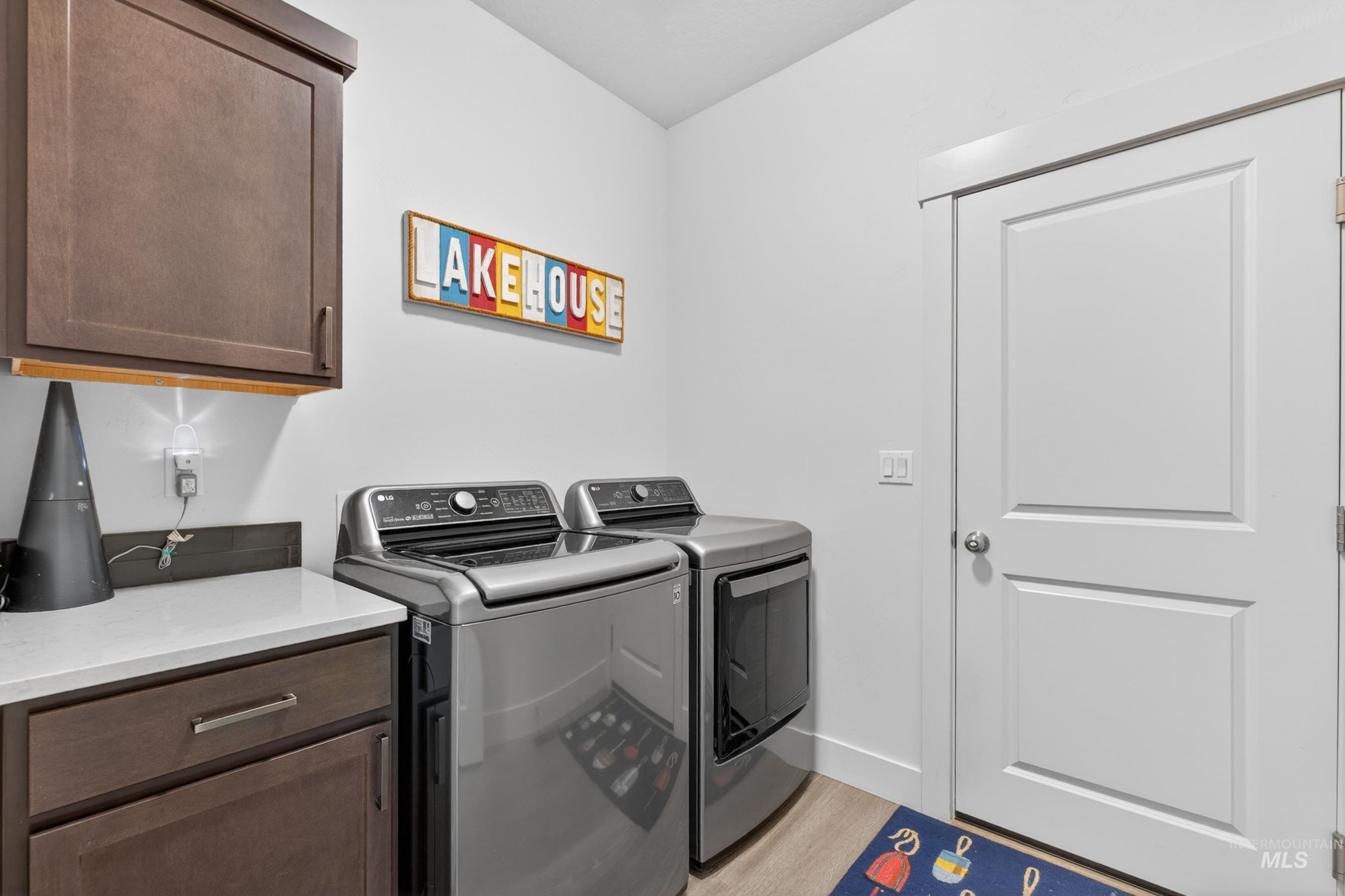1126 Mo's Way McCall, ID 83638 - Photo 29 of 50 Laundry area featuring overhead cabinetry, a light-toned countertop, and wood-finish flooring