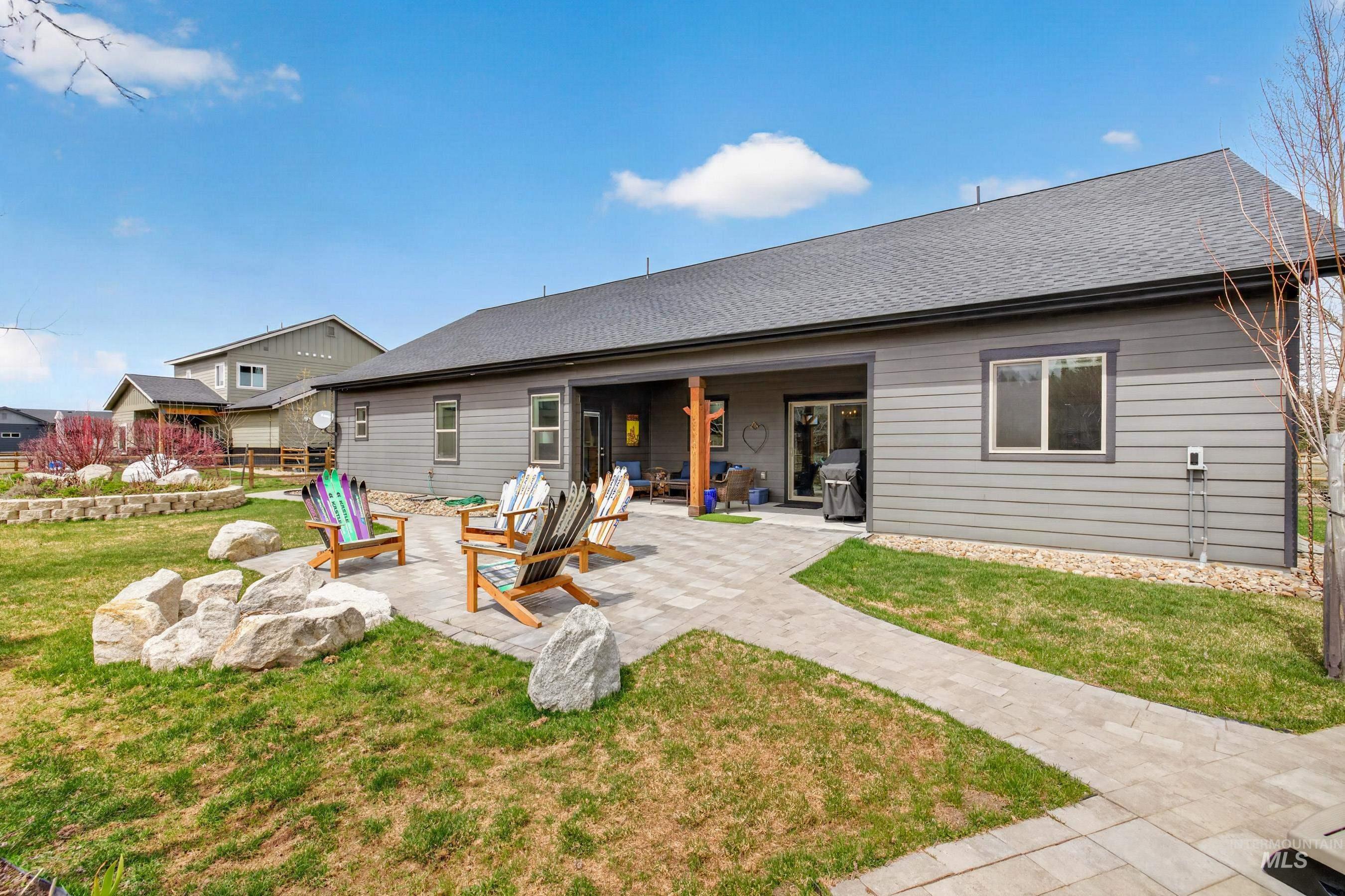 1126 Mo's Way McCall, ID 83638 - Photo 41 of 50 Expansive backyard featuring a paver patio and walkways, a covered outdoor living area, and a rock-lined garden bed