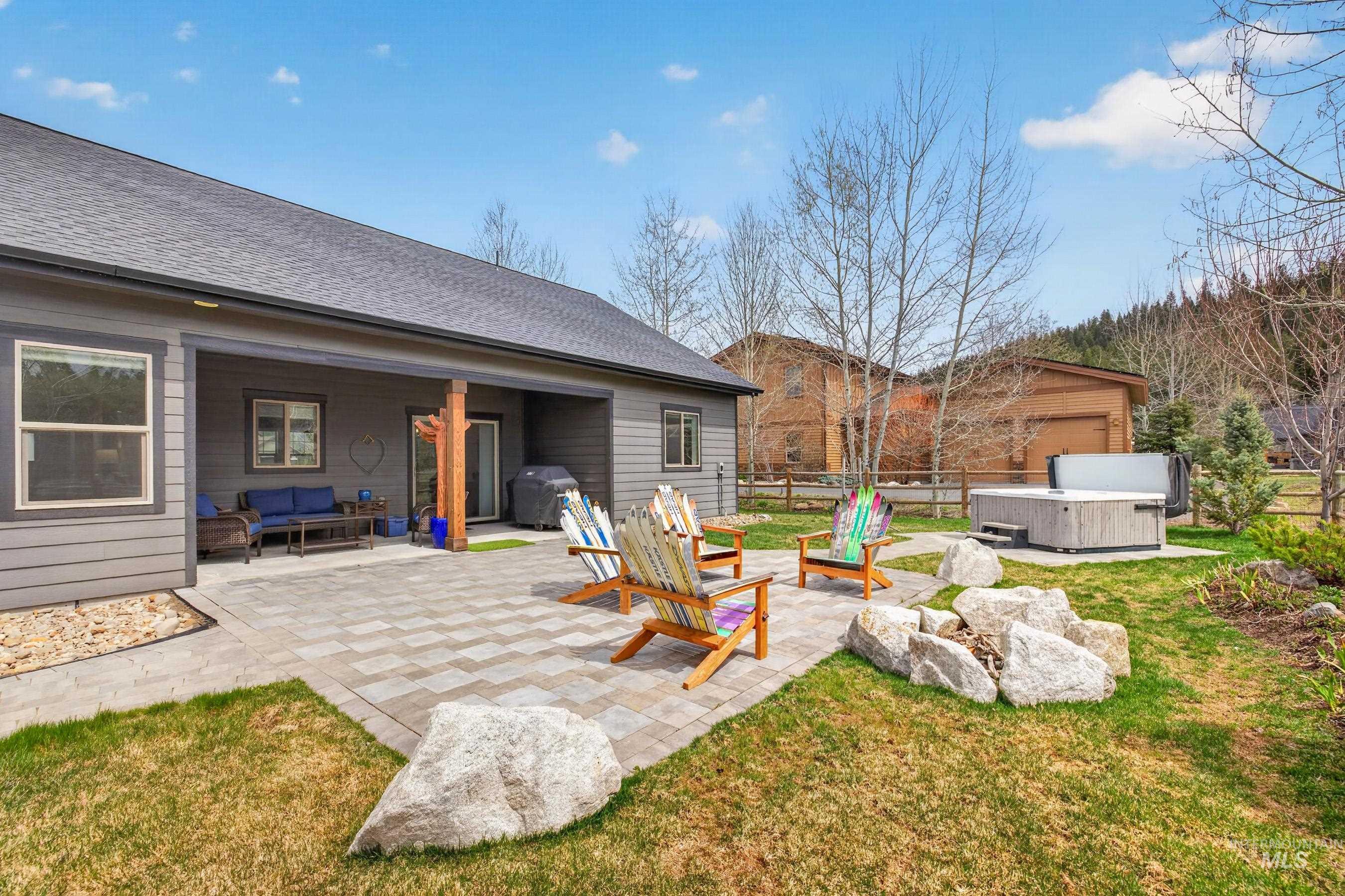 1126 Mo's Way McCall, ID 83638 - Photo 42 of 50 Expansive backyard featuring a paver patio with a built-in fire pit, a hot tub, and a covered patio area