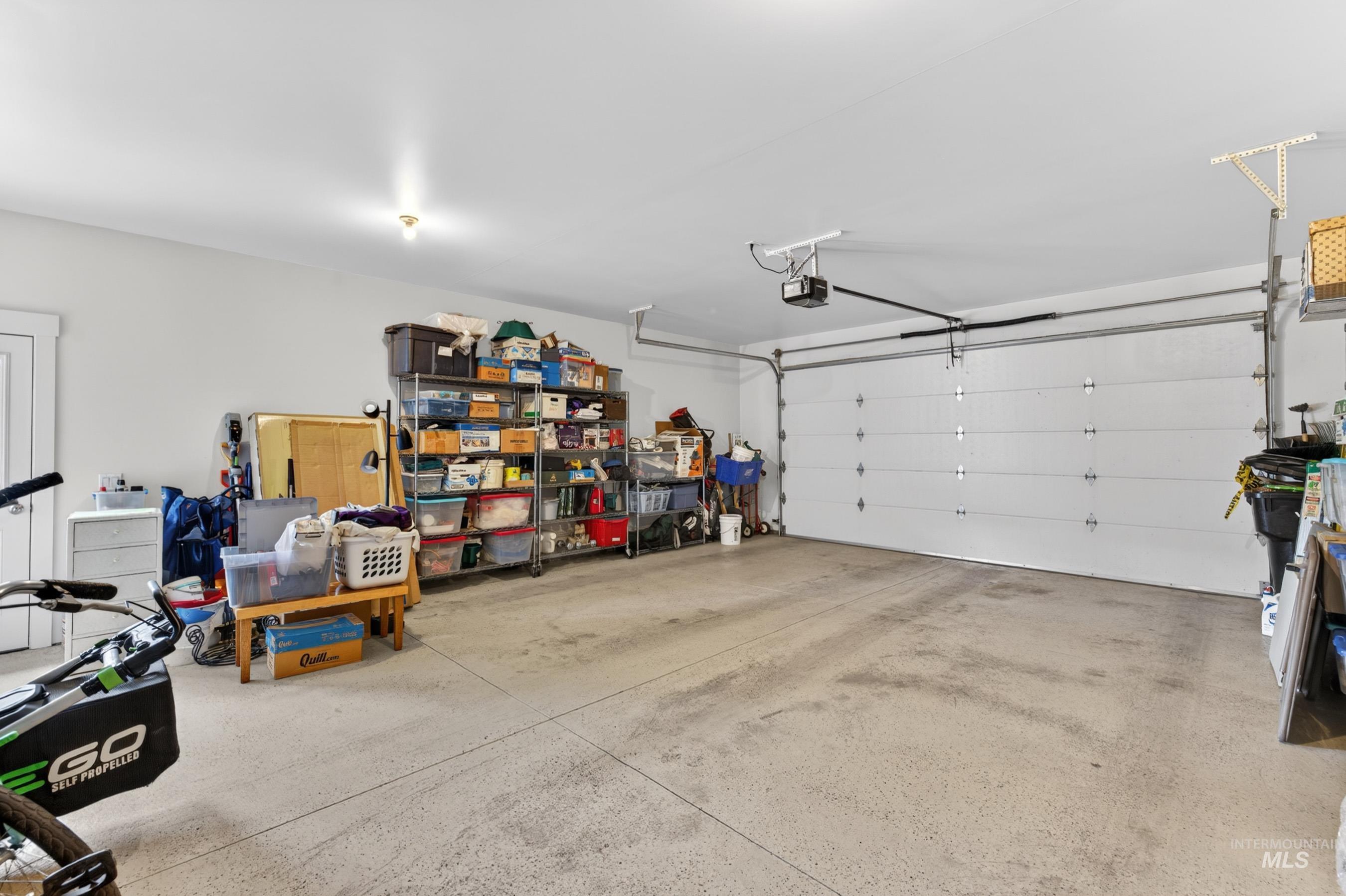 1126 Mo's Way McCall, ID 83638 - Photo 44 of 50 Attached garage featuring a white overhead door, concrete flooring, and an automatic garage door opener