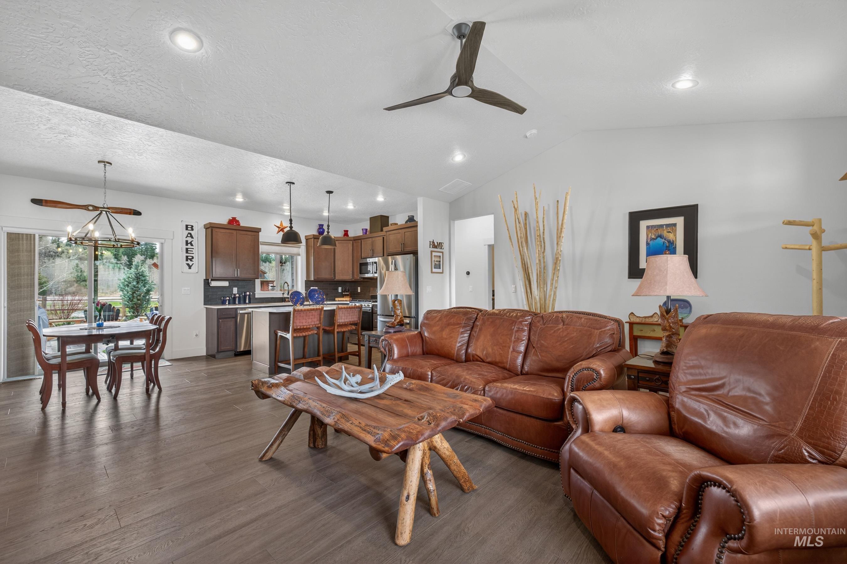1126 Mo's Way McCall, ID 83638 - Photo 10 of 50 Open-concept living area featuring wood-finish flooring, a vaulted ceiling with recessed lighting, and a modern ceiling fan