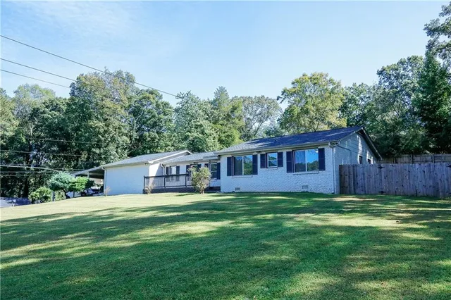 a view of a house with a big yard and large trees