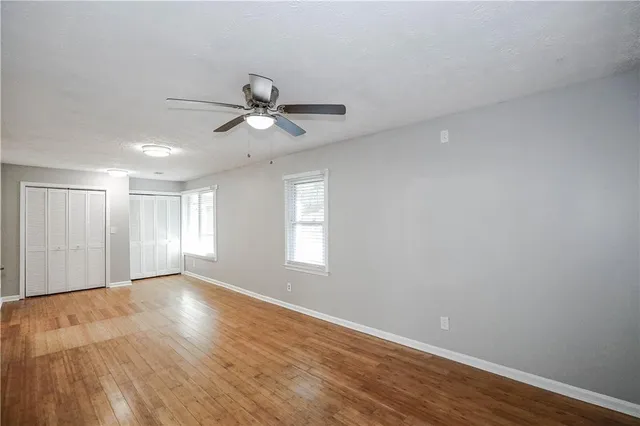a view of a big room with wooden floor and a ceiling fan