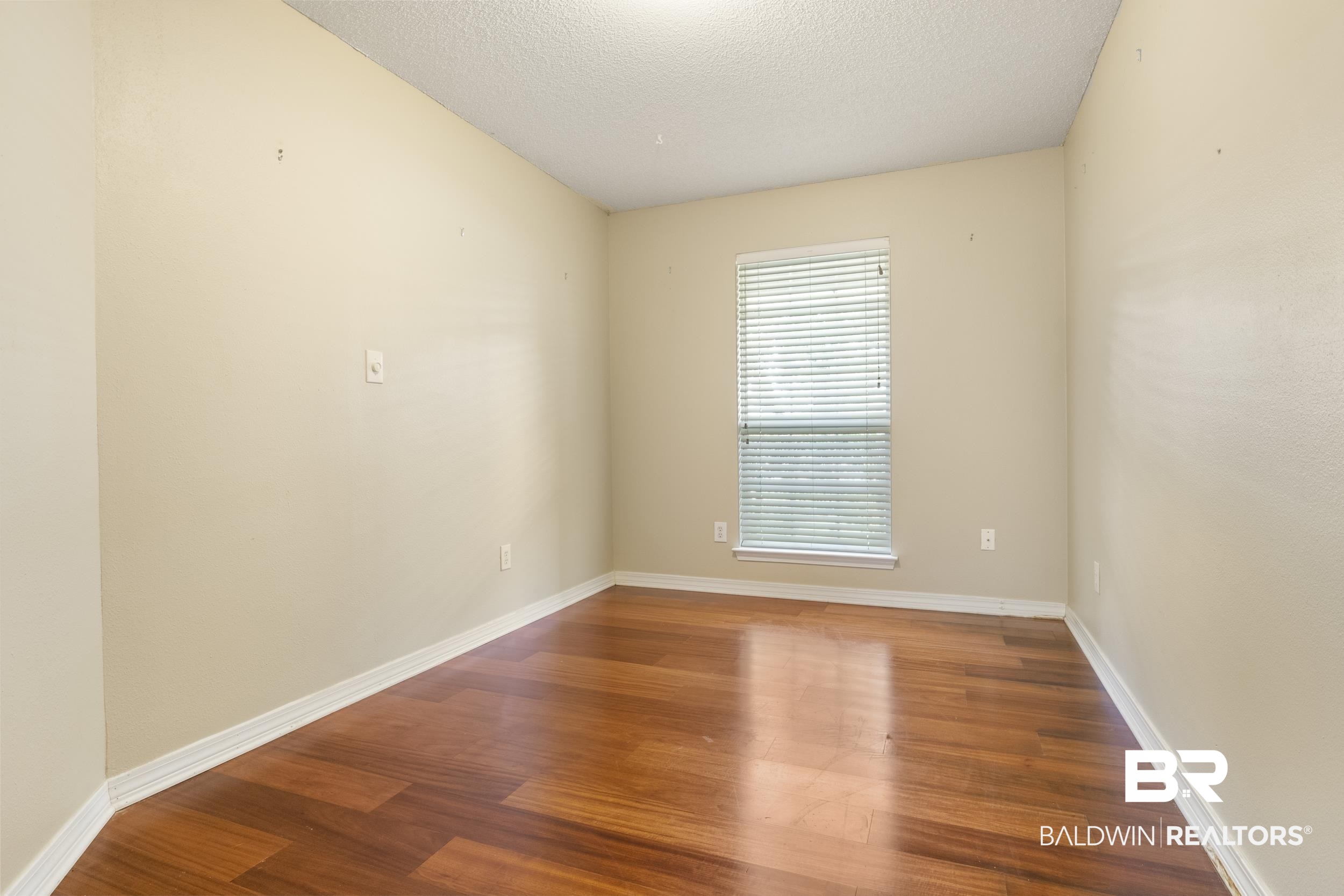 9610 Watkins Drive Fairhope, AL 36532 - Photo 10 of 26 Spare room with wood-type flooring and a textured ceiling