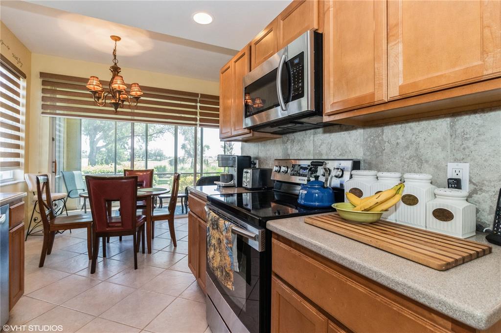 3010 Meandering Way, Unit 101 Fort Myers, FL 33905 - Photo 11 of 37 a kitchen with stainless steel appliances granite countertop a stove a sink a microwave and dining table