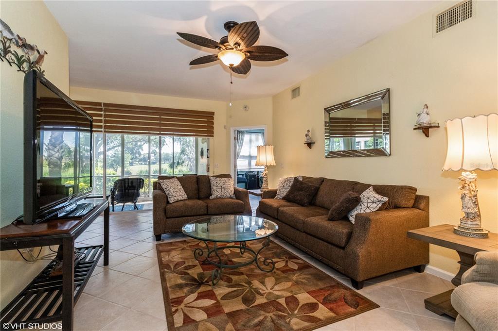3010 Meandering Way, Unit 101 Fort Myers, FL 33905 - Photo 6 of 37 a living room with furniture a ceiling fan and a large window
