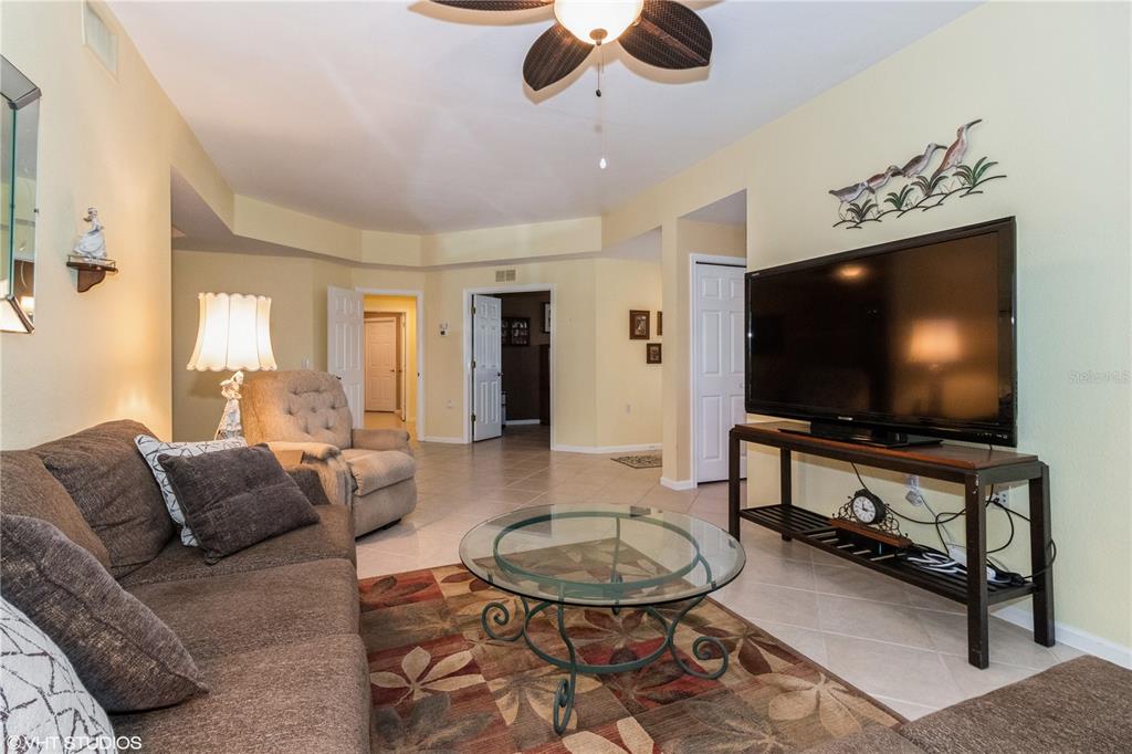 3010 Meandering Way, Unit 101 Fort Myers, FL 33905 - Photo 8 of 37 a living room with furniture and a flat screen tv