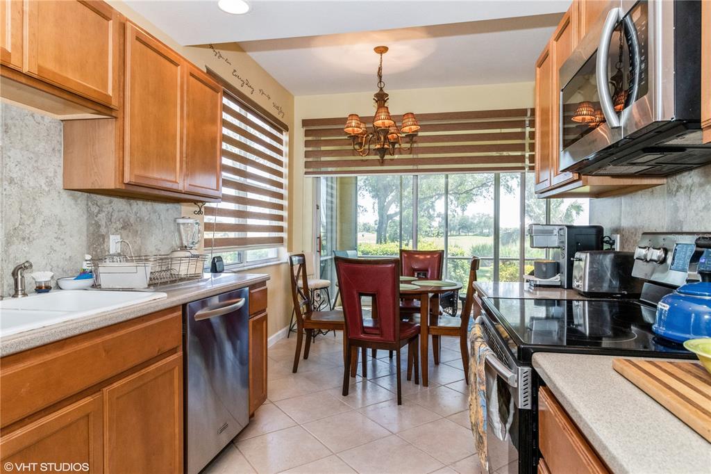 3010 Meandering Way, Unit 101 Fort Myers, FL 33905 - Photo 10 of 37 a kitchen filled with a stove a sink a dining table and chairs