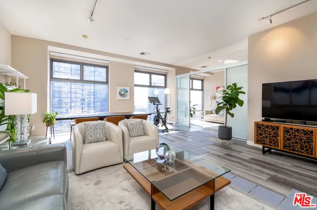 a living room with furniture a flat screen tv and a large window