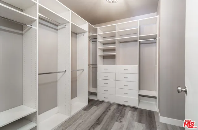 a view of walk in closet with empty racks