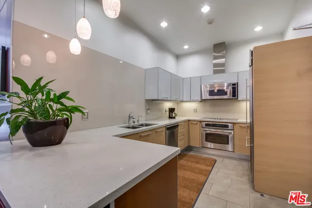 a kitchen with stainless steel appliances granite countertop a sink a stove and a refrigerator