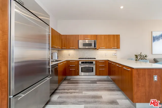 a kitchen with stainless steel appliances granite countertop a refrigerator and a stove