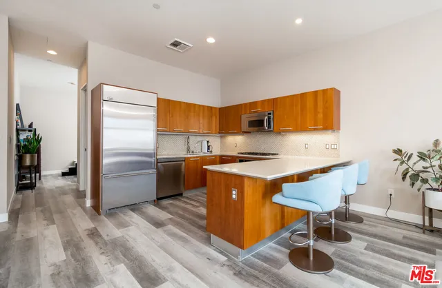 a kitchen with stainless steel appliances granite countertop a sink a stove and a refrigerator