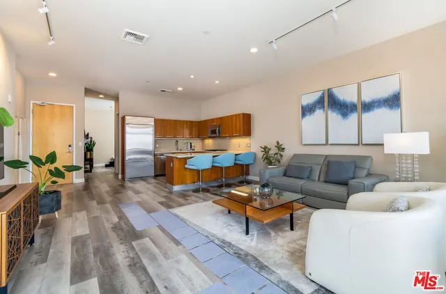 a living room with furniture and kitchen view